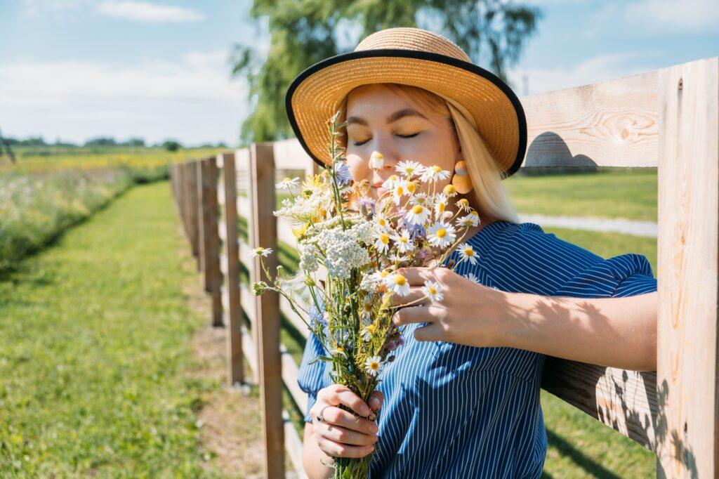 Frau mit Blumen an Holzzaun | Stalleinrichtung